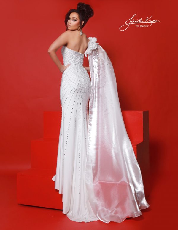 Back view of white embellished pageant gown with cape, pearl-studded back design and train detail, showing full-length cape perfect for red carpet and grand entrances.